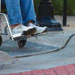 A Wheel chair user can be seen accessing a curb cut 